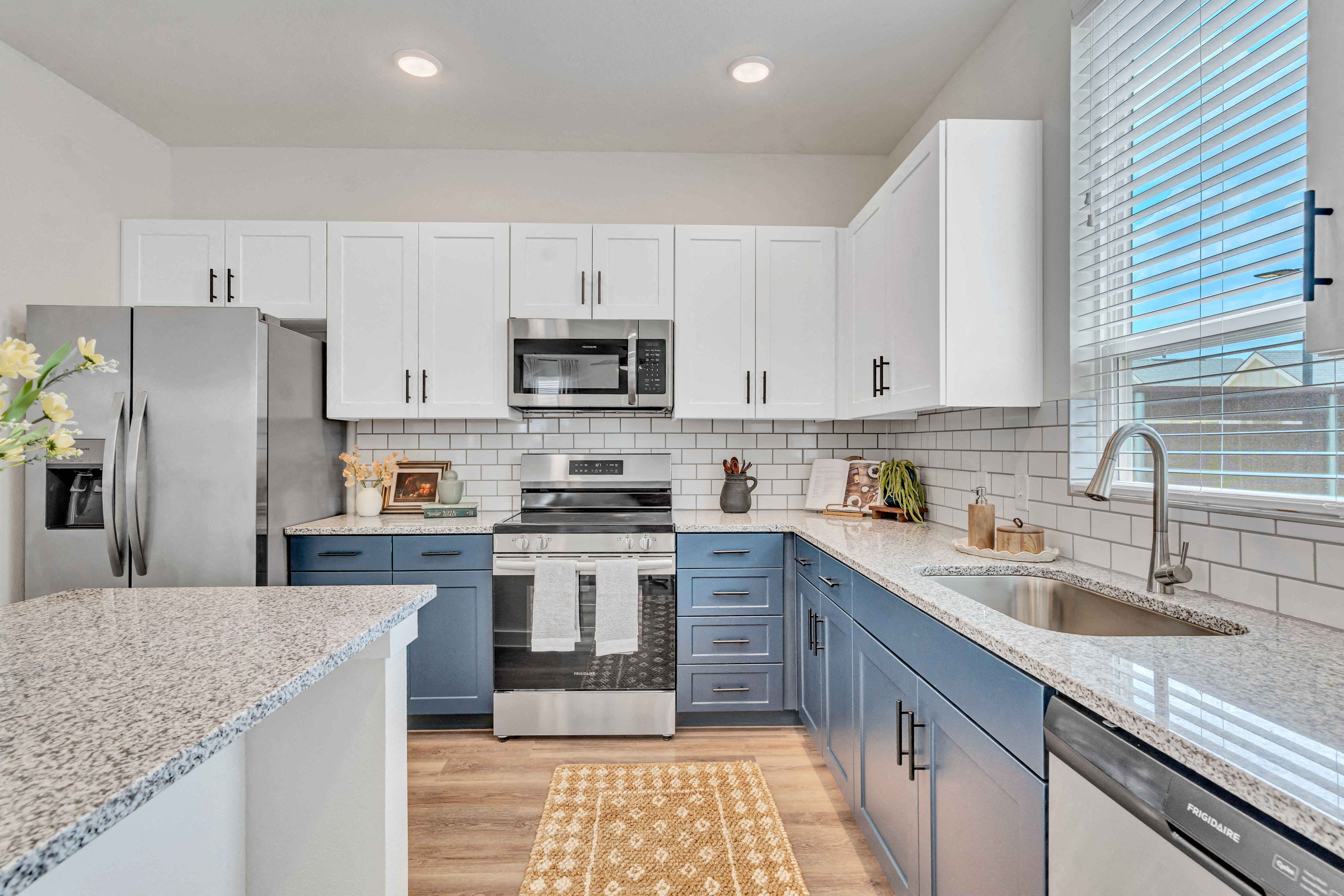 a white and blue kitchen with a sink and a stove